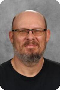 a bald man with glasses smiles at the camera